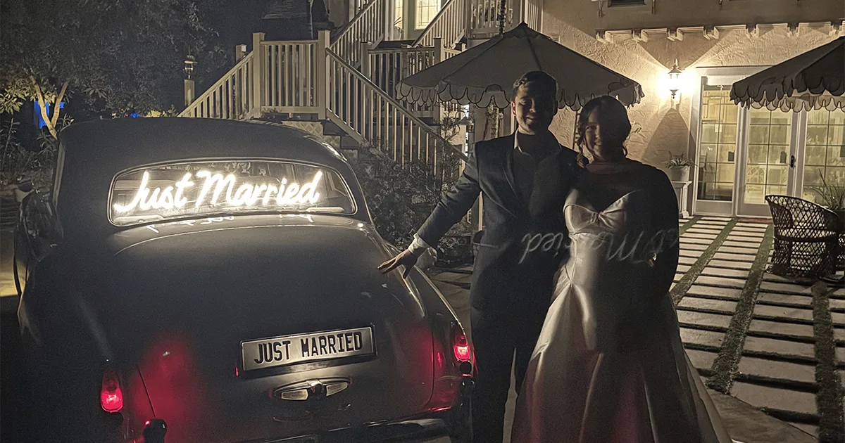 Just Married Rolls-Royce Palmira Golf Club Wedding Naples Florida August 2026 Newlyweds standing beside a vintage Rolls-Royce Silver Cloud II with a glowing Just Married neon sign at night in Naples Florida